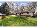 Beautifully landscaped front yard featuring mature trees and a well-maintained lawn at 2840 Cottonwood Dr, Denver, CO 80221
