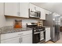 Updated kitchen showcasing granite countertops and stainless steel appliances at 2954 E 101St Ave, Thornton, CO 80229