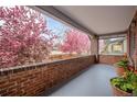 Charming covered porch with brick railing and a view of flowering trees at 3311 N York St, Denver, CO 80205