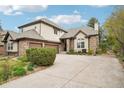 Charming home exterior featuring a three-car garage, stone and stucco details at 1474 S Uinta Ct, Denver, CO 80231