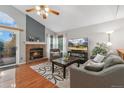 Cozy living room with a brick fireplace, plush seating, and ample natural light at 6452 Freeport Dr, Highlands Ranch, CO 80130