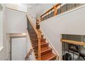 Elegant staircase featuring wood steps, decorative wrought iron railing, and natural light at 6452 Freeport Dr, Highlands Ranch, CO 80130