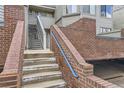 Exterior staircase with brick wall and blue railing for easy access to upper-level units at 3260 47Th St # 108A, Boulder, CO 80301