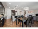 Open-concept kitchen with dark wood cabinets, granite island, stainless appliances, hardwood floors, and adjacent living area with fireplace at 655 Tiger Lily Way, Highlands Ranch, CO 80126