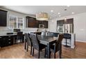 Stylish kitchen with an island, dark wood cabinets, granite countertops, stainless steel appliances, dining area and hardwood floors at 655 Tiger Lily Way, Highlands Ranch, CO 80126