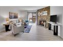 Inviting living room featuring a stone fireplace and sliding glass doors to a balcony at 11985 E Harvard Ave # 108, Aurora, CO 80014