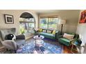 Cozy living room featuring a green sofa and large windows at 1303 Newport St, Denver, CO 80220