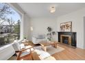 Bright living room featuring a classic fireplace, hardwood floors, and a large arched window at 169 W Byers Pl, Denver, CO 80223