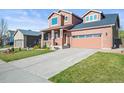 Beautiful home featuring brick accents, a spacious driveway, and a well-maintained lawn at 11373 Kearney Way, Thornton, CO 80233