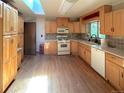 Well-lit kitchen with wood floors, light cabinets, and a skylight providing natural light at 1115 S Harlan St, Lakewood, CO 80232