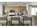 Open concept kitchen with quartz countertops, stainless steel appliances, and stylish barstool seating at 21166 E 62Nd Dr, Aurora, CO 80019