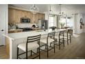 Eat-in kitchen featuring a large center island with seating, stainless steel appliances and modern light fixtures at 21166 E 62Nd Dr, Aurora, CO 80019