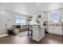 Inviting open concept space with island seating that connects the living room and the kitchen at 503 S Rollie Ave # 12D, Fort Lupton, CO 80621