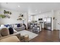 Bright open concept living area with modern decor, wood floors, and seamless flow to the kitchen at 503 S Rollie Ave # 12D, Fort Lupton, CO 80621
