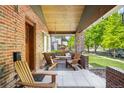Relaxing front porch with comfortable seating, brick columns, and a view of the neighborhood street at 2669 N Cherry St, Denver, CO 80207
