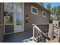 A warm welcome awaits at the front door, complete with a welcome mat and wood accents at 29691 Fairway Dr, Evergreen, CO 80439