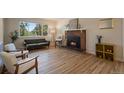 Bright living room with a brick fireplace and views of the surrounding forest through large windows at 29691 Fairway Dr, Evergreen, CO 80439