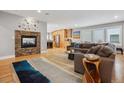 Open-concept living room featuring a stone fireplace, wood floors, and ample natural light at 1526 S Gaylord St, Denver, CO 80210