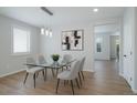 A formal dining room with a glass table, modern chandelier and a view into the next room at 21482 E Idyllwilde Dr, Parker, CO 80138