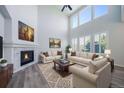 Inviting living room features a soaring ceiling, large windows, fireplace, and comfortable seating at 21482 E Idyllwilde Dr, Parker, CO 80138