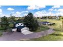Two-story home with a two-car garage and outbuildings on acreage at 17800 E Hinsdale Ave, Foxfield, CO 80016