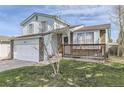 Two-story home with light-blue siding, brick accents, front porch, well-kept lawn, and an attached garage at 19485 E Purdue Pl, Aurora, CO 80013
