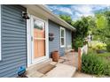 Cozy front porch with charming peach-colored door and view of small outdoor seating area at 3175 S Pennsylvania St, Englewood, CO 80113