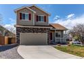 Charming two-story home with a red door, stone accents, an attached garage and well-kept landscaping at 5549 Helena St, Denver, CO 80239