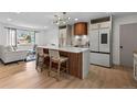Open-concept kitchen with island seating, modern lighting, and seamless flow to the living area at 690 S Newark Ct, Aurora, CO 80012