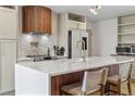 Close up of the bright kitchen island, showcasing a waterfall countertop and wood accents at 690 S Newark Ct, Aurora, CO 80012
