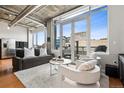 Modern living room with large windows, concrete ceilings, and stylish furniture at 1401 Wewatta St # 911, Denver, CO 80202