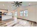 Open living area with wood floors and a view of the kitchen and sliding door to back yard at 523 Beckwourth Ave, Fort Lupton, CO 80621
