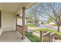 Covered front porch view looking out at the peaceful neighborhood street at 741 Hallmark Ln, Longmont, CO 80504