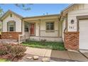 Inviting front porch with brick accents and a meticulously landscaped garden bed at 741 Hallmark Ln, Longmont, CO 80504