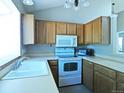 Functional kitchen equipped with essential appliances, ample cabinet space, and a sink with a view at 9669 W Chatfield Ave # A, Littleton, CO 80128