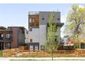 Modern three-story home with wood and grey paneled design and wood fence at 1581 King St, Denver, CO 80204