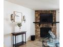 Stone fireplace with mounted TV, hardwood floors and a glass coffee table at 14413 E Jewell Ave # 201, Aurora, CO 80012