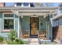 Inviting front porch featuring decorative ironwork, brick accents, and comfortable seating at 2445 N Franklin St, Denver, CO 80205