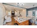 Open-concept kitchen and living area with large island, granite countertops, and modern appliances at 9675 E 105Th Ave, Commerce City, CO 80640