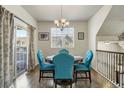 Bright dining room featuring hardwood floors, a modern chandelier, and patio doors at 9225 Rockhurst St # A, Highlands Ranch, CO 80129