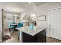 Bright kitchen with granite island, a nearby dining area, and a staircase leading to the second floor at 9225 Rockhurst St # A, Highlands Ranch, CO 80129
