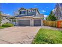Two-story home showcasing a three-car garage and landscaped front yard at 17280 W 70Th Ave, Arvada, CO 80007
