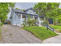 Light blue house with a gravel driveway, green lawn, and a view of the well-maintained exterior at 3396 S Logan St, Englewood, CO 80113