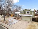 Aerial view of charming two-story home with a two-car garage and landscaped front yard in winter at 3293 S Fairplay St, Aurora, CO 80014