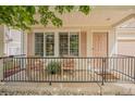 Inviting front porch features charming furniture, decorative shutters, and a secure black metal railing at 19481 E 50Th Pl, Denver, CO 80249