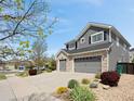 Charming two-story home featuring a three-car garage, stone accents, gray siding, and well-maintained landscaping at 15915 E Summit Fox Ave, Parker, CO 80134