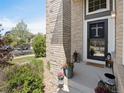 Inviting front porch with brick detailing, stylish lanterns, potted plants and a welcoming 'Hello' doormat at 15915 E Summit Fox Ave, Parker, CO 80134