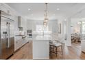 Bright, open-concept kitchen featuring a large island, stainless steel appliances, and modern lighting fixtures at 2141 Fountain Cir, Erie, CO 80516