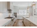 Spacious kitchen with stainless steel appliances, a gas cooktop, white cabinetry and an island with bar seating at 2141 Fountain Cir, Erie, CO 80516