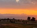 Beautiful evening view of the Rocky Mountains and the Colorado skyline near a paved road and fields at 2141 Fountain Cir, Erie, CO 80516